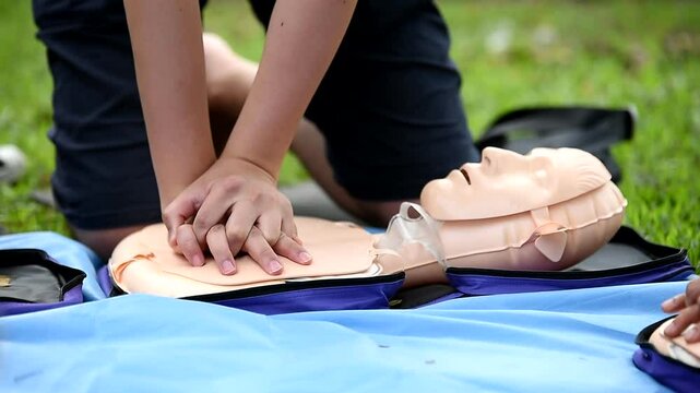 CPR Training, Emergency First Aid Outdoors Class on CPR Doll for Rescuing Unconscious Person With Cardiopulmonary Resuscitation