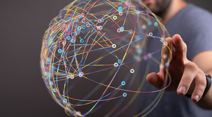 Abstract image of a man interacting with a digital sphere representing global networking and...