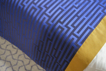 Elegant graphic Art Deco design pattern of day blanket in blue and gold on double queen king bed...