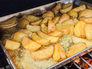 Quartered Small Potatoes Roasting In A Pan On A Grill With Butter