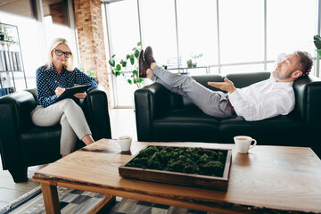 Professional consulting session with a mature individual speaking to an attentive female consultant...