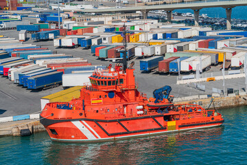 Fototapeta premium Workboat Docked at Cargo Terminal with Shipping Trailers