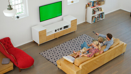 Overhead Shot Of Family Sitting On Couch At Home Watching TV Together