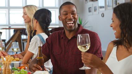 Close Up Of Friends Sitting Around Table At Dinner Party At Home