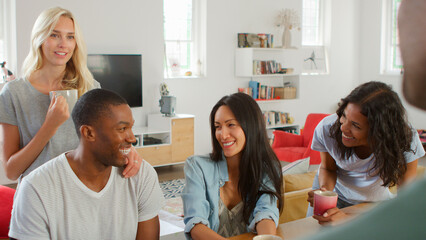 Fototapeta premium Group Of Young Multi Cultural Friends Chatting And Drinking Coffee In Kitchen At Home Together