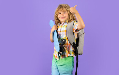 Kid with skateboard on violet studio background. Child hold skate board. Healthy sport and activity for school kids in summer. Sports fun.