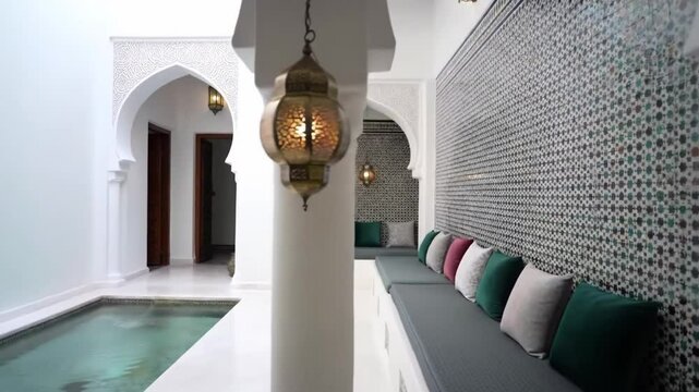 Traditional Moroccan riad interior with pool and ornate details.