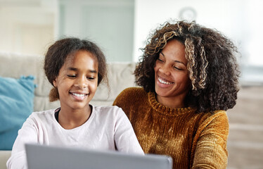 Mother and daughter doing homework with laptop at home. Mom, dad and teenage black girl happy using laptop. Teen girl and parents sitting at home working with notebook