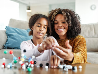 Portrait of a child daughter with mother having fun together playing board game or learningcell and...