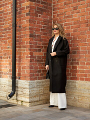 Stylish woman in casual streetstyle coat enjoying a sunny day in the city
