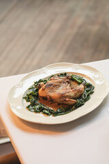 Portion of gourmet baked chicken with spinach