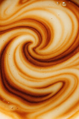 Fototapeta premium Swirling patterns of coffee and cream blend together in a warm beverage