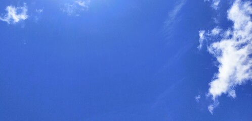 Azure Horizon: An awe-inspiring view of a cerulean sky, adorned with scattered, fluffy clouds, evoking feelings of peace and tranquility.