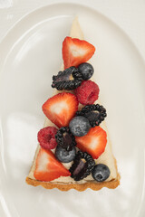 Portion of cheesecake dessert with assorted berries