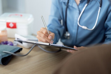 Healthcare Consultation. Medical professional taking notes during patient checkup.