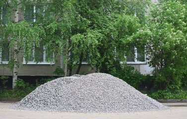 A large pile of gray rubble is scattered under the windows of an apartment building