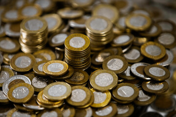 Close up of a lot of Ghanaian cedi coins with few notes spread on desk