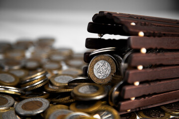 Ghanaian cedi coins in container poured on and spread on desk