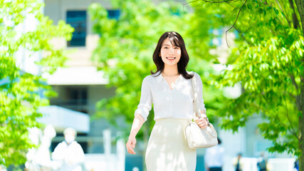夏の屋外を歩く笑顔の女性・ビジネスウーマン