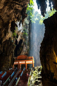 Visitors climbing colorful steps inside Batu Caves, Kuala Lumpur