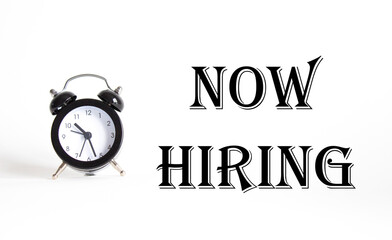 Now Hiring symbol. Concept word Now Hiring on Beautiful white background with alarm clock. Business...