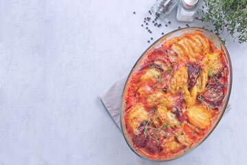 Gratin with sweet potato, parsnips, beet root and melted cheese, horizontal top view, copy space