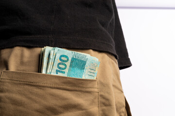 A Man With Brazilian 100 Reais Banknotes on his pocket on white background