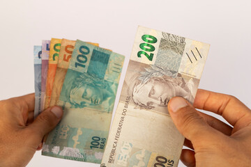 Hands of a Man Holding Brazilian Bank Notes Reais ready to pay