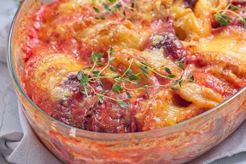 Sweet potato, parsnips and beet root au gratin, in glass dish, horizontal closeup