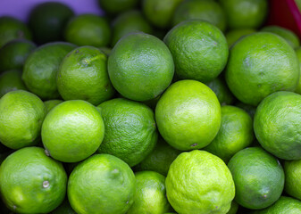 Fresh green limes forming a vibrant pile at the market