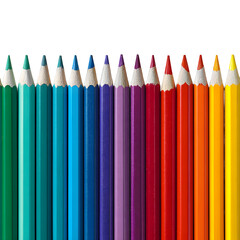 A vibrant row of sharpened colored pencils creates a bright spectrum against a stark dark background.