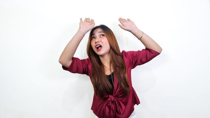 Beautiful asian woman wearing red blouse expressing fear and screaming while avoiding something...