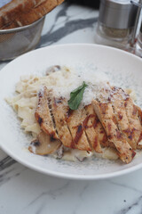 Delicious grilled chicken served on creamy fettuccine pasta