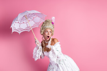 Sophisticated aristocratic woman in Baroque-era gown with lace parasol on pink backdrop, capturing...