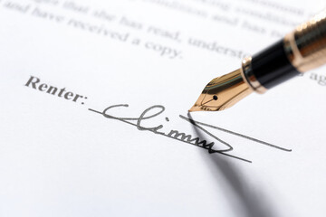 Fountain pen leaving signature on contract, closeup