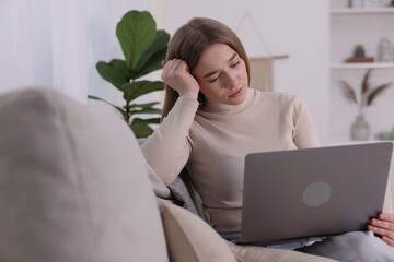 Cyber bullying. Upset teenage girl with laptop on sofa at home