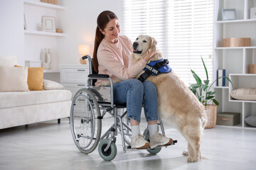 Woman in wheelchair hugging her service dog at home