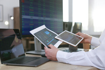 Stock exchange. Man working at desk in office, closeup