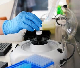 Laboratory technician conducting analysis with centrifuge in modern research facility during daytime