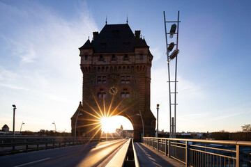 A road or highway leads through an old historic city gate. Sunset in the evening over the Rhine...