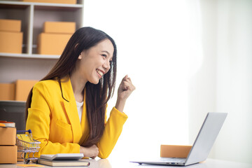 Beautiful Asian business woman starting her SME business using her home as an office or Home Office...
