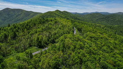 Aerial View of Twisting Mountain Road though Blue Ridge Mountains surrounded by forest 