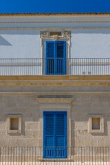Stone and white roughcast facade with blue shutters