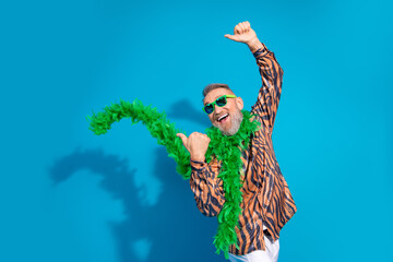 Cheerful Cheerful Stylish Senior Man in Colorful Outfit Gesturing Joyfully Against a Blue Background