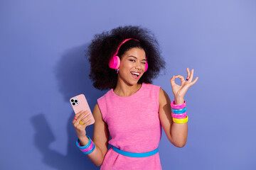 Charming young girl enjoying music, expressing joy with retro style accessories against a vibrant...