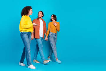 Fototapeta premium Three young individuals sharing joyful conversation and laughter, symbolizing multicultural diversity