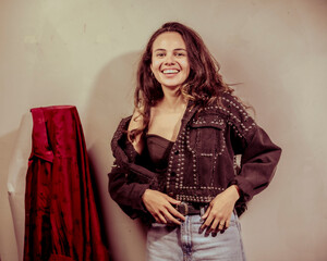 In this image, a smiling woman radiates joy and style as she flaunts a captivating jacket adorned...