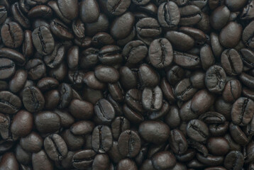 Close-up of stacked whole coffee beans. Horizontal background.