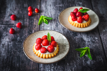 Homemade strawberry tartlets on dark wooden table