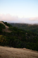 Blanket of fog rolling over a mountain ridge at sunrise